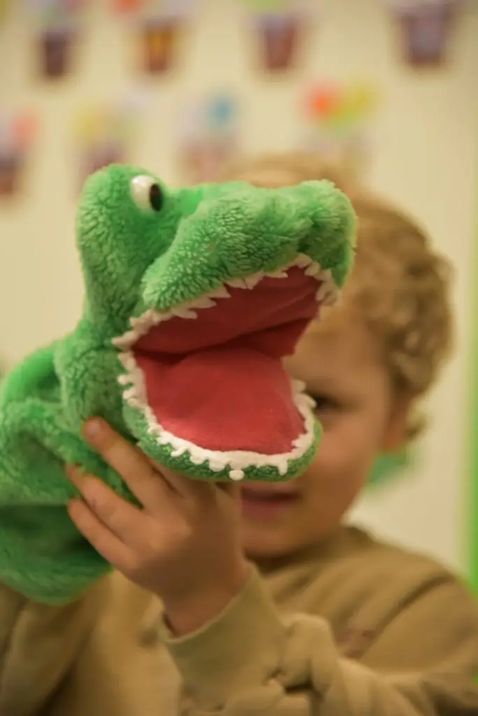 Kind spielt mit einer Krokodil Handpuppe