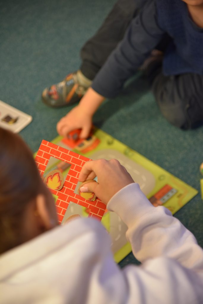 Kinder spielen auf dem Boden in einem Gruppenraum