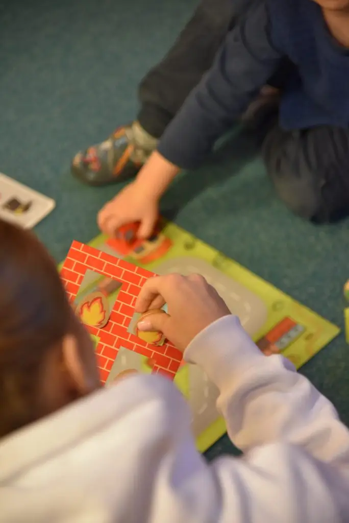 Kinder spielen auf dem Boden in einem Gruppenraum